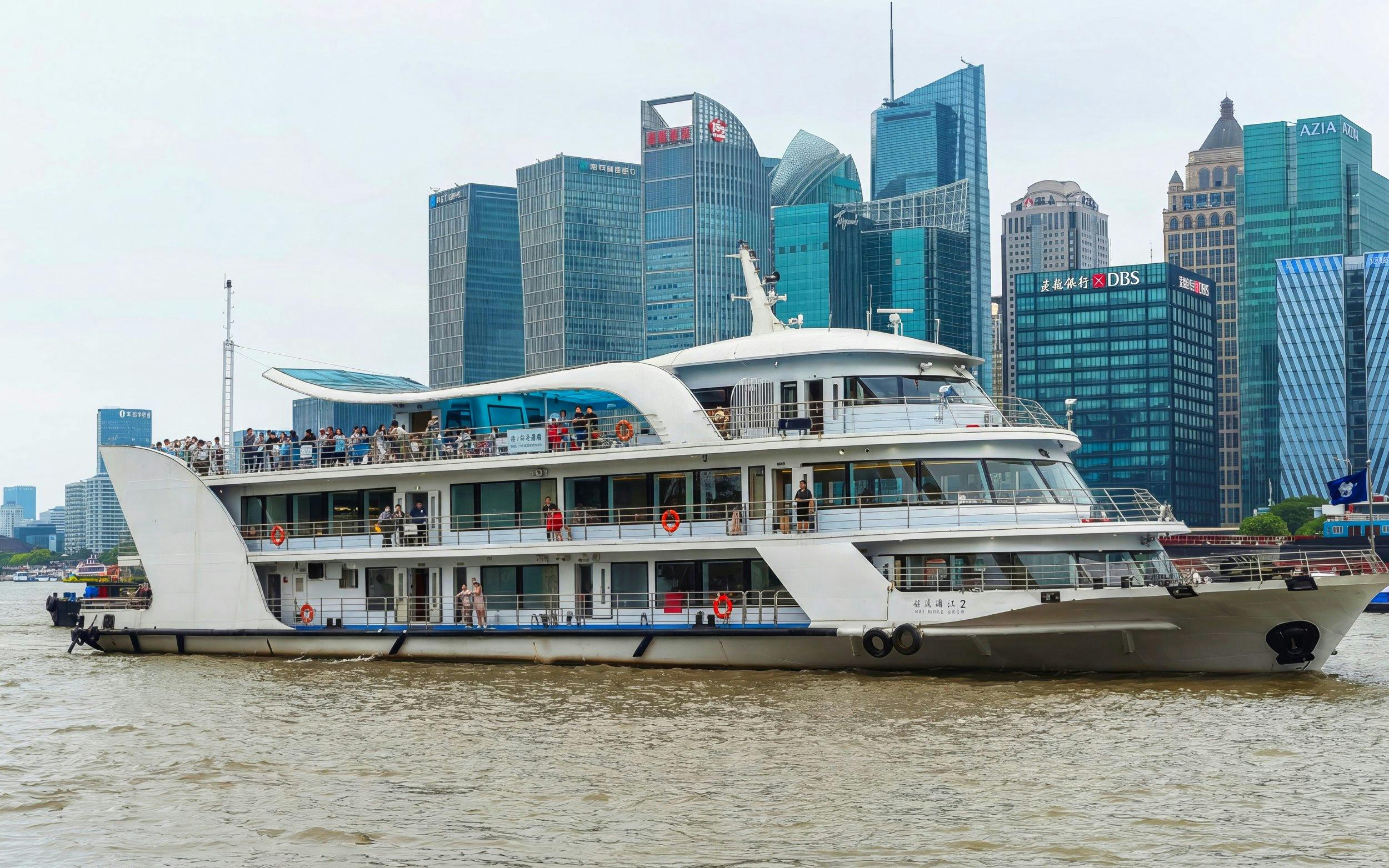 Cruise ship on the Huangpu River with Shanghai skyline in the background.