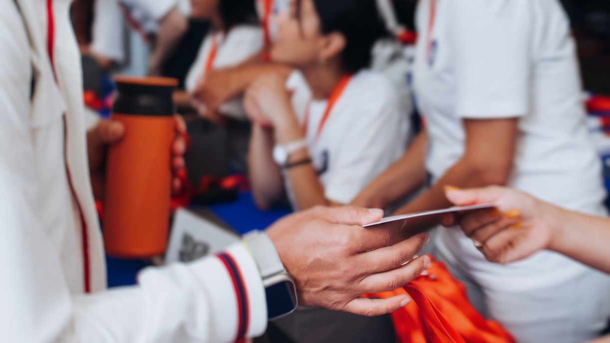 Ticket being checked at a front desk with staff in the background.