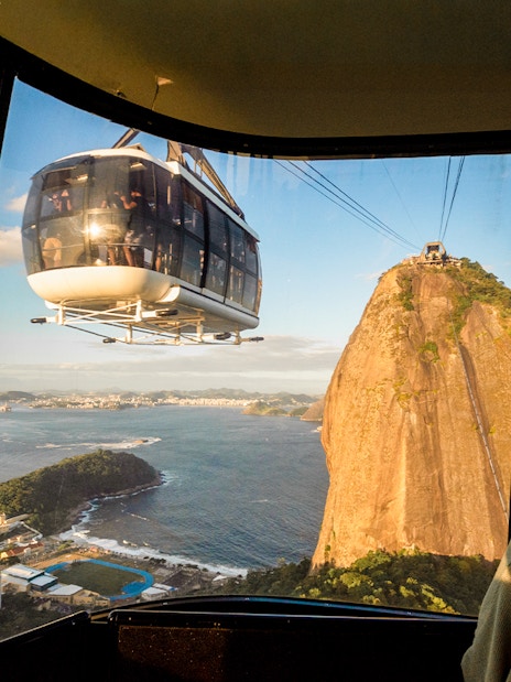 Cable car approaching Sugar Loaf Mountain at sunset, Rio de Janeiro.