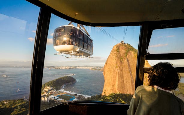 Cable car approaching Sugar Loaf Mountain at sunset, Rio de Janeiro.