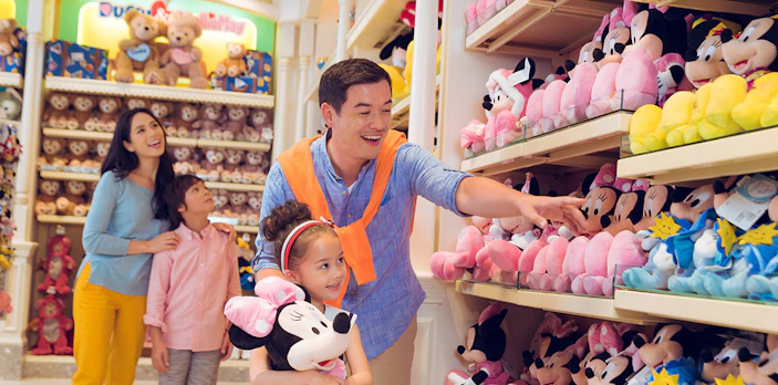 Family shopping for Disney plush toys at Disneyland Hong Kong store.