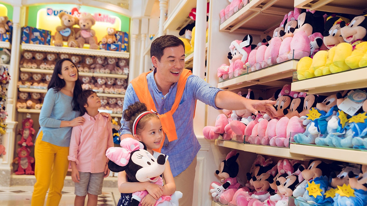 Family shopping for Disney plush toys at Disneyland Hong Kong store.