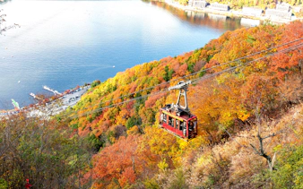 Cable car ascending Mount Fuji with autumn foliage in Fujikawaguchiko, Japan.