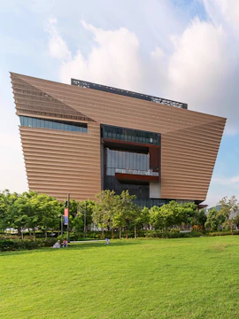 Hong Kong Palace Museum modern architecture with green lawn in foreground.