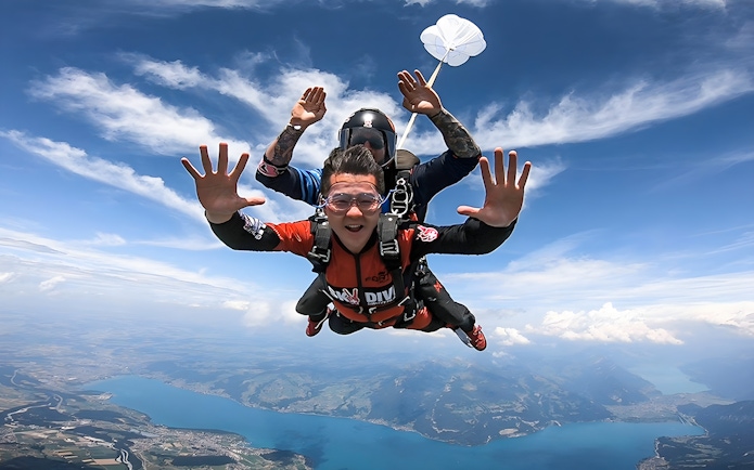Skydivers tandem freefalling over Lake Thun in Interlaken, Switzerland.
