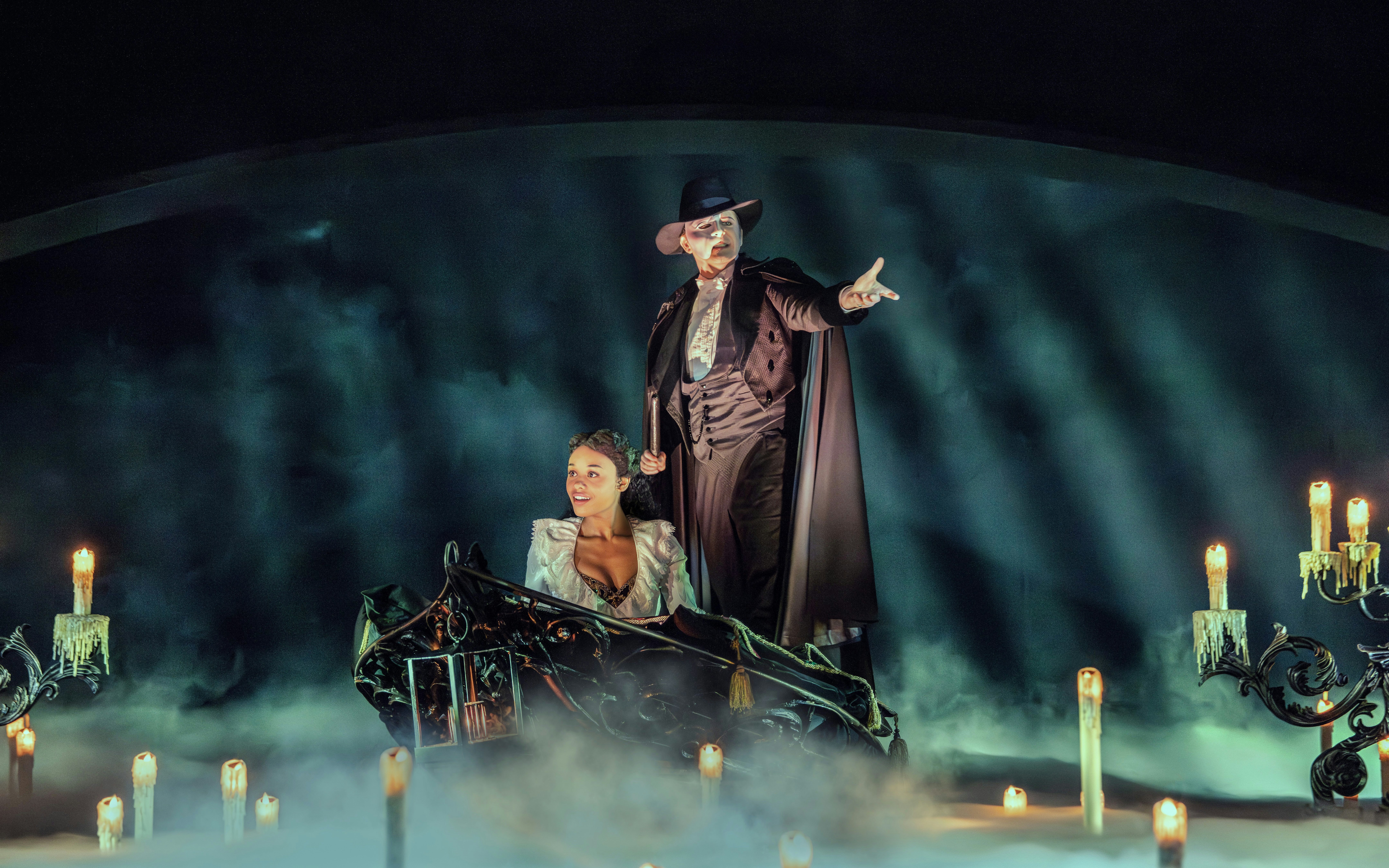 Phantom of the Opera scene with characters on a boat surrounded by candles and mist.