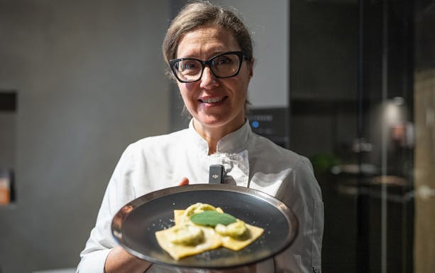 Chef presenting homemade ravioli during a cooking class in Rome.