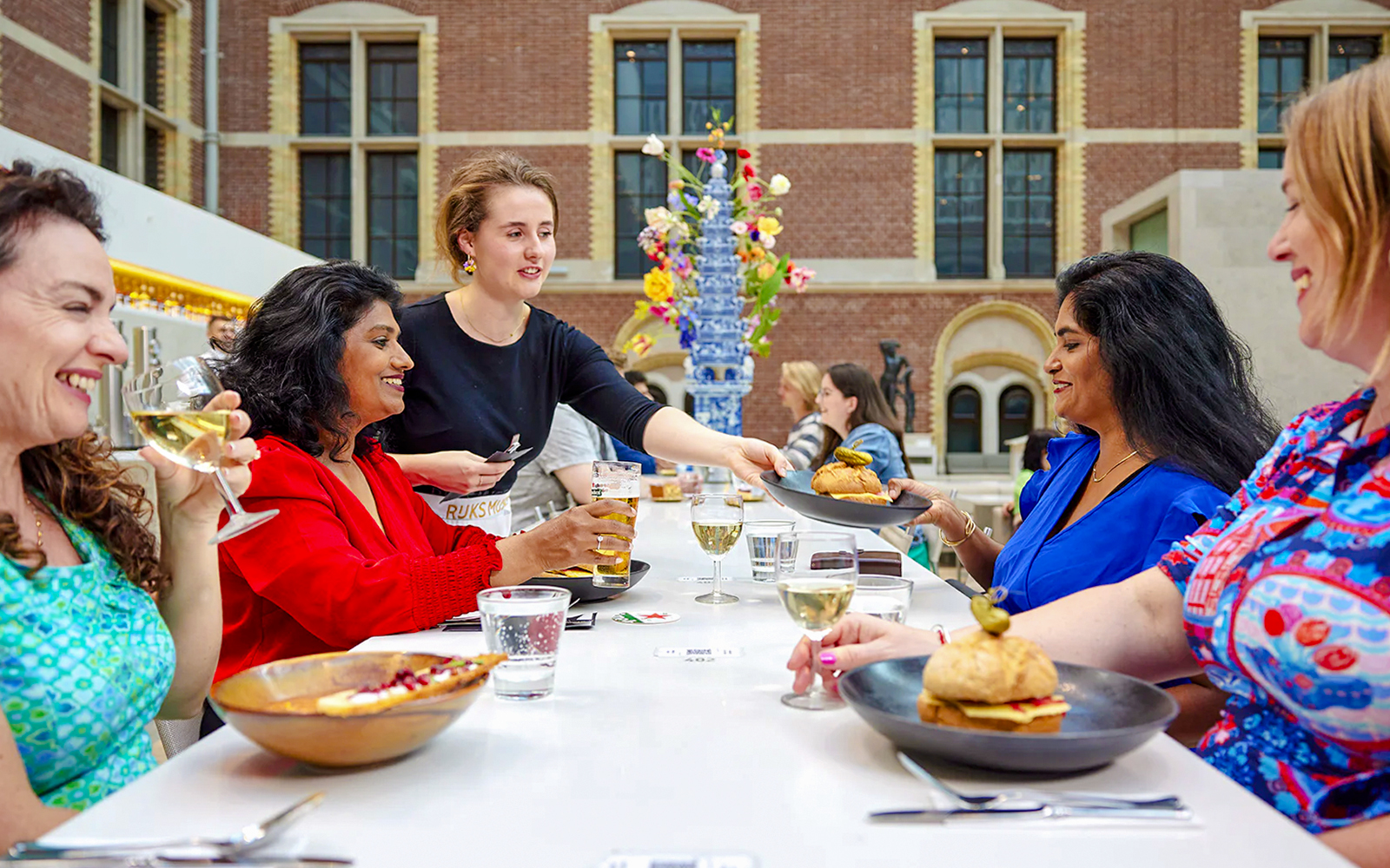 Visitors enjoying drinks and food at Rijksmuseum cafe in Amsterdam.