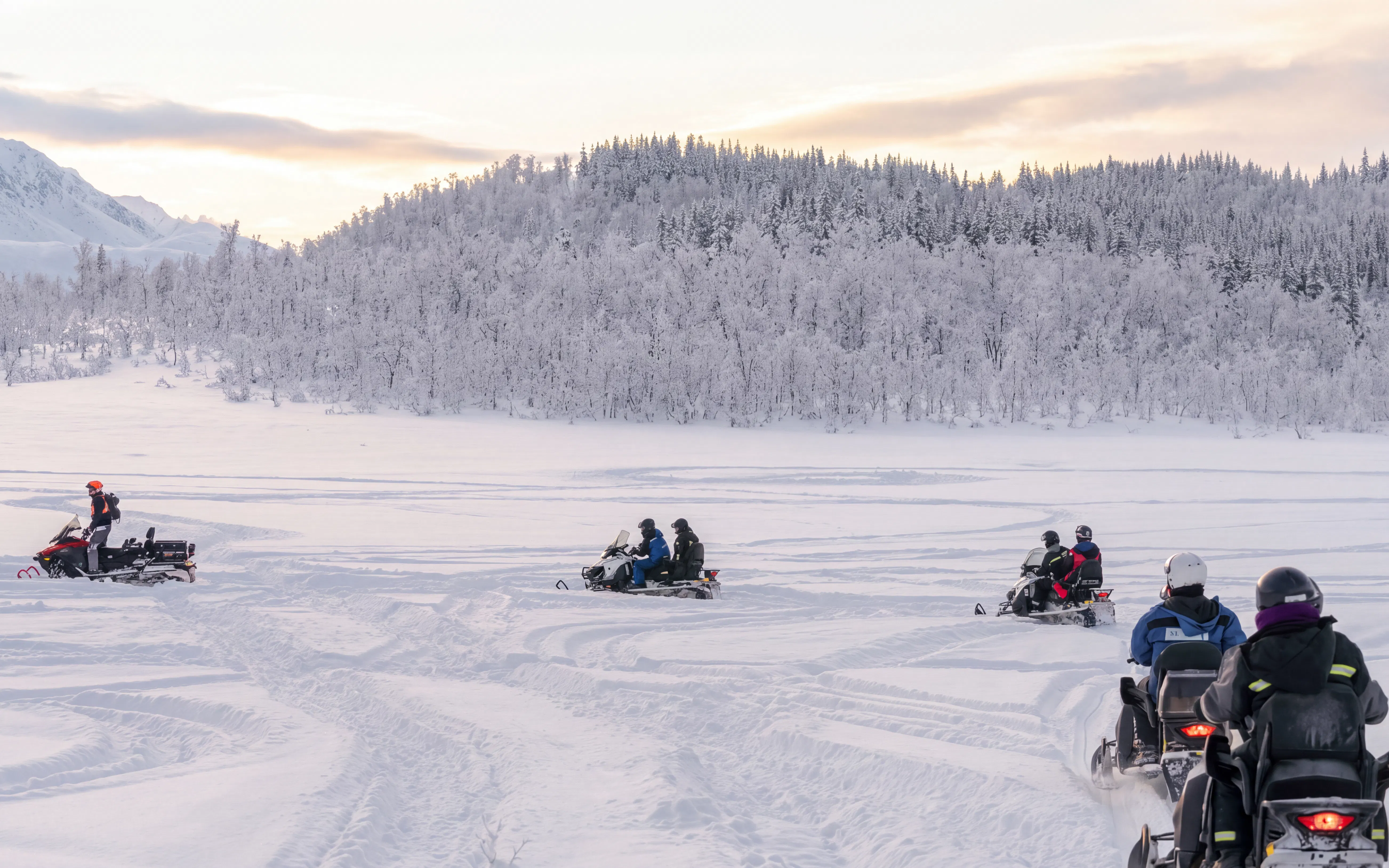 Snowmobile riders in snowy Lyngen Alps, Tromsø.