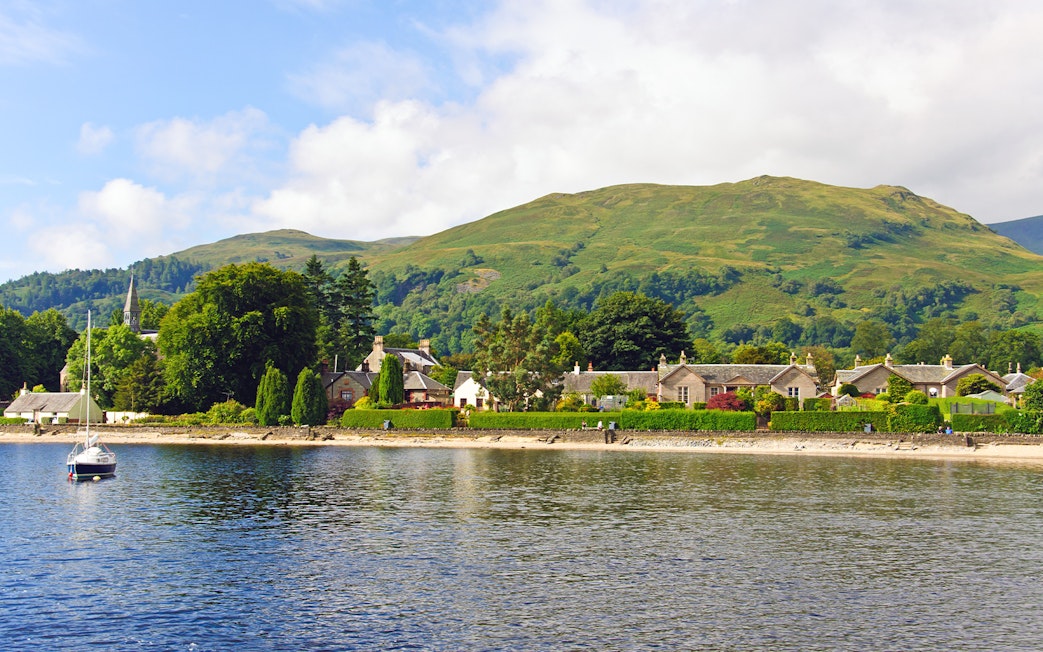 Luss village viewed from Loch Lomond with Scottish hills in the background.