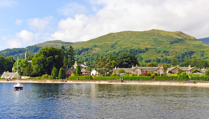 Luss village viewed from Loch Lomond with Scottish hills in the background.