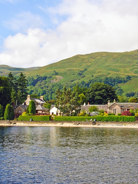 Luss village viewed from Loch Lomond with Scottish hills in the background.