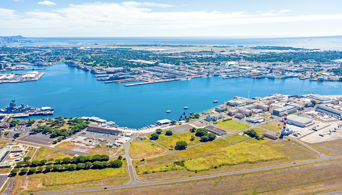 Aerial view of Pearl Harbor, showcasing historic battleships and surrounding waters in Honolulu, Hawaii.
