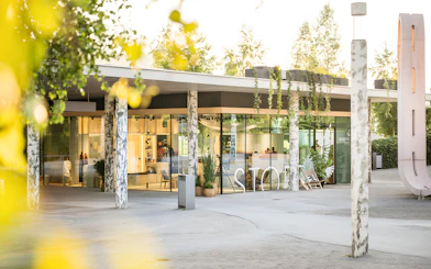 Swarovski Crystal Worlds entrance with modern glass facade and surrounding greenery.