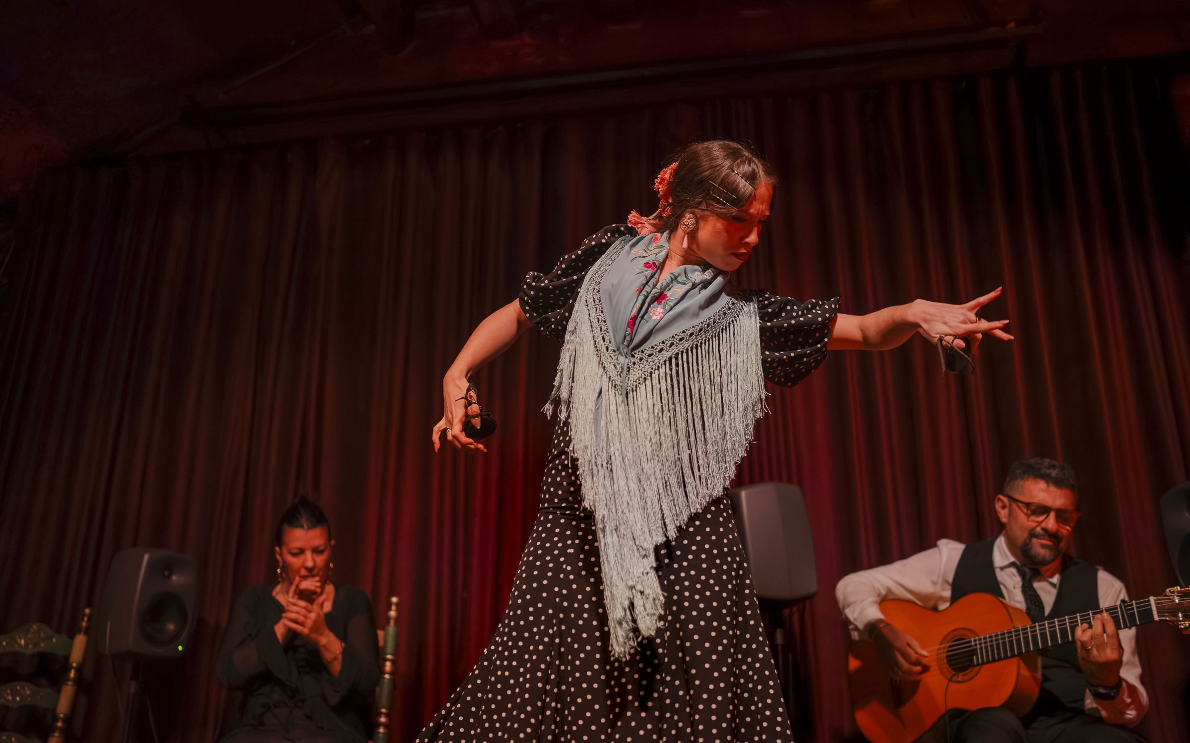 Flamenco dancer performing at Palau Dalmases with guitarist and singer.