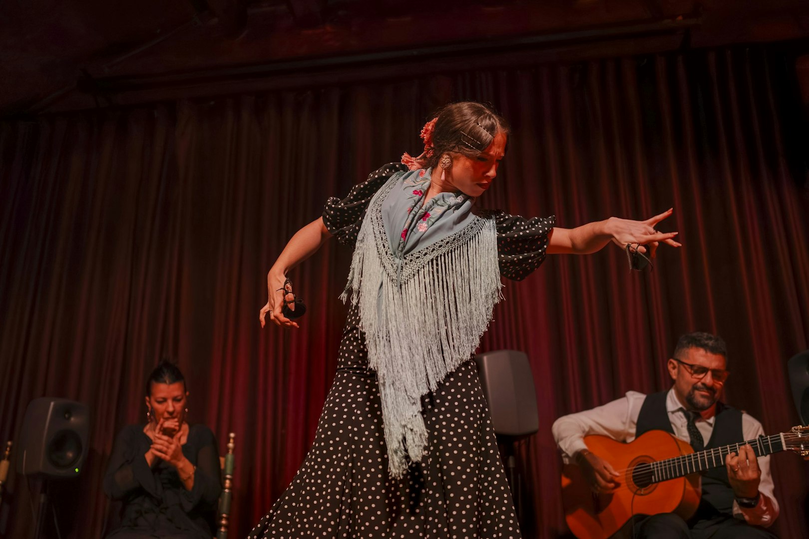 Flamenco dancer performing at Palau Dalmases with guitarist and singer.