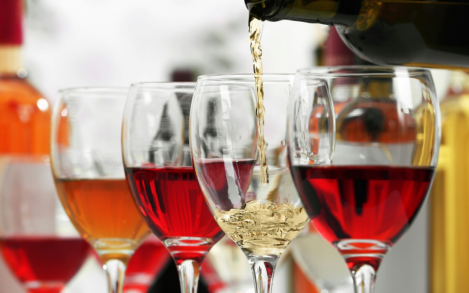 White wine pouring into glasses, closeup