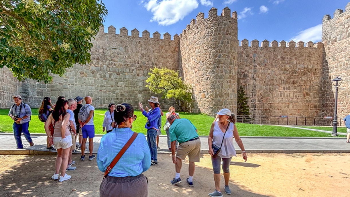 Visitors observing the historic Avila Wall on a guided tour from Madrid.