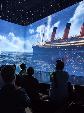 Visitors watching Titanic projection at immersive exhibit in Utrecht.