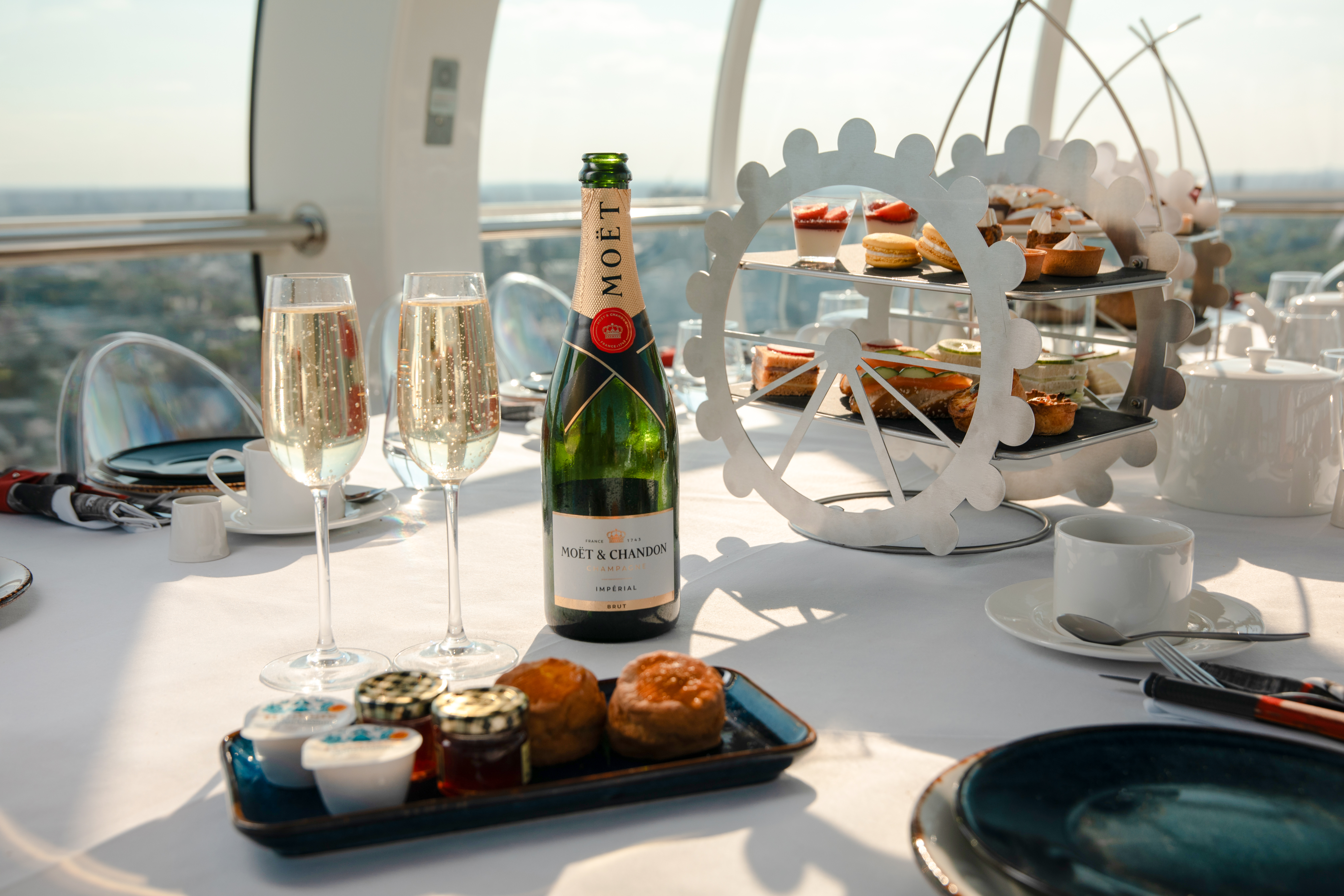 London Eye Afternoon Tea with champagne, pastries, and scones on a table inside the capsule.