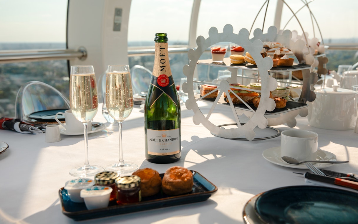 London Eye Afternoon Tea with champagne, pastries, and scones on a table inside the capsule.