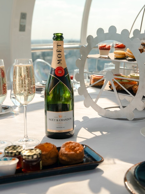 London Eye Afternoon Tea with champagne, pastries, and scones on a table inside the capsule.