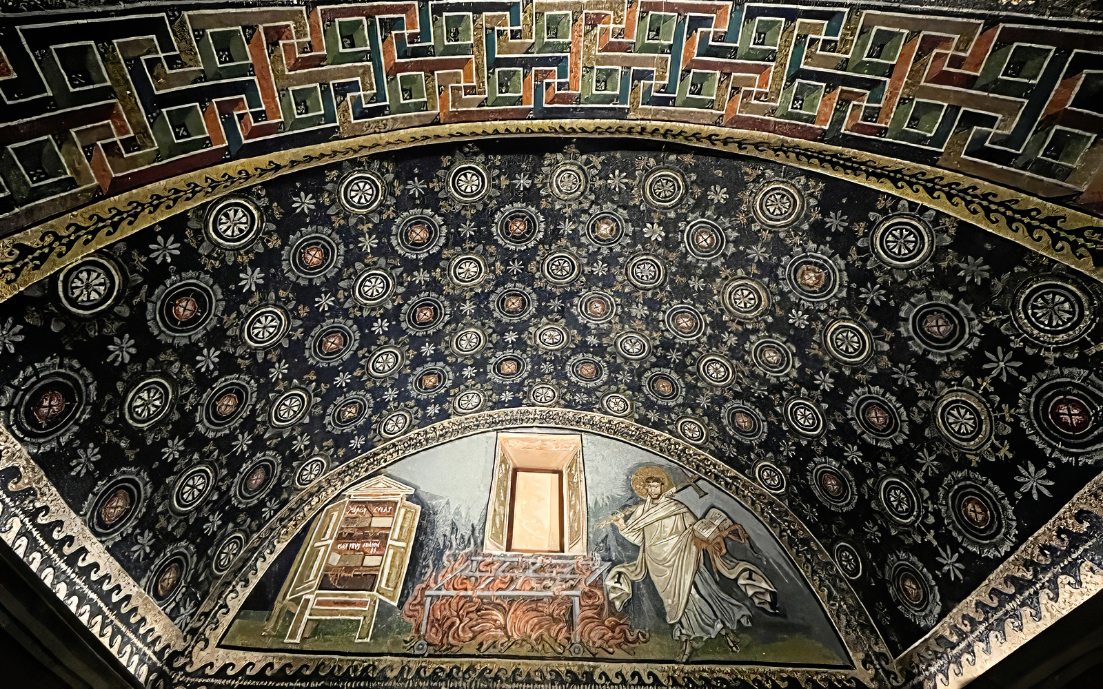 Mosaic ceiling with intricate patterns and religious imagery in Ravenna UNESCO monument.