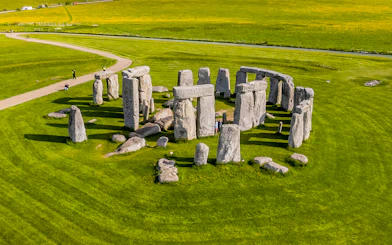 Tourists walking around Stonehenge on a day trip from London.