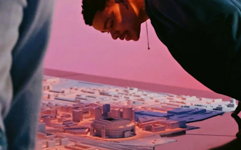 Man examining a detailed architectural model of Amsterdam.