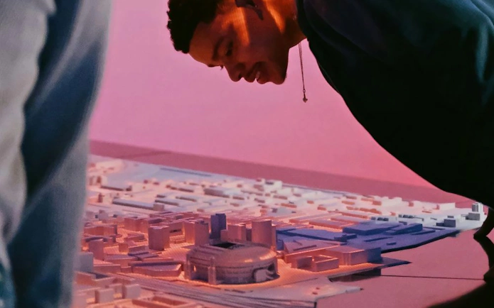 Man examining a detailed architectural model of Amsterdam.
