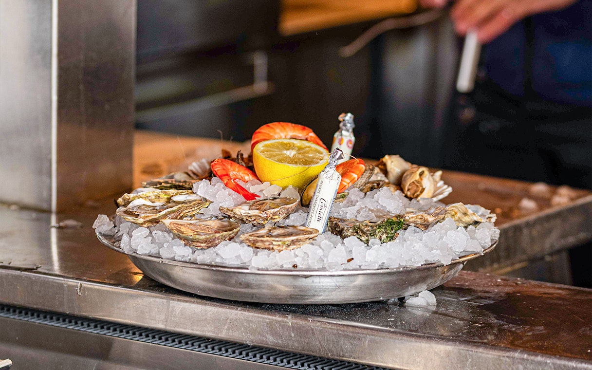 Seafood platter with oysters, shrimp, and lemon at Opéra-Grand Café Capucines, Paris.