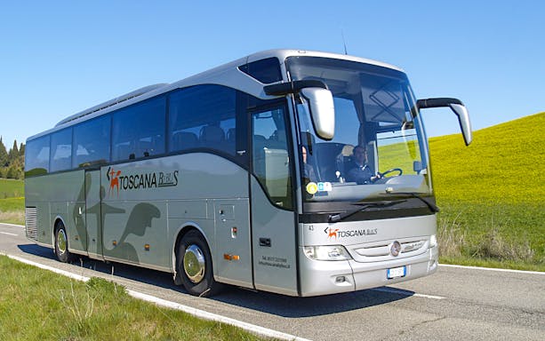 Bus traveling between Rome Fiumicino Airport and Siena on a scenic road.