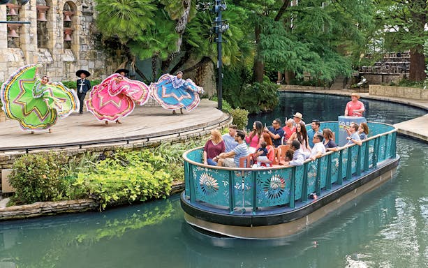 Riverboat tour with traditional dancers performing in San Antonio, Texas.