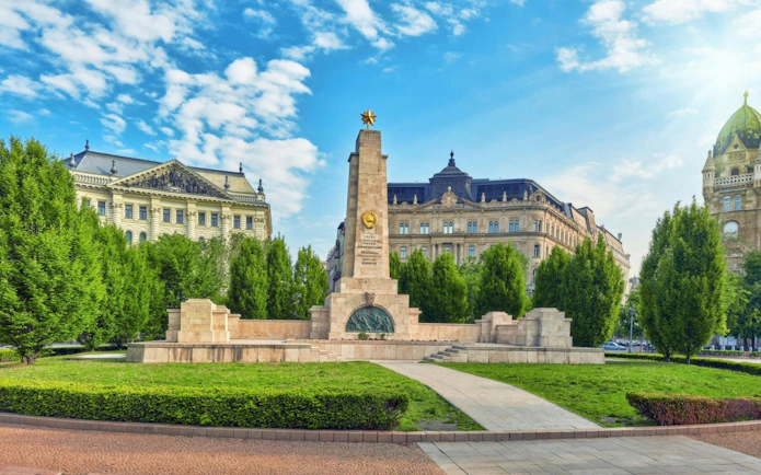 Soviet War Memorial in Liberty Square, Budapest, with historic buildings in the background.