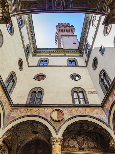 Palazzo Vecchio courtyard with ornate columns and tower view, Florence, Italy.