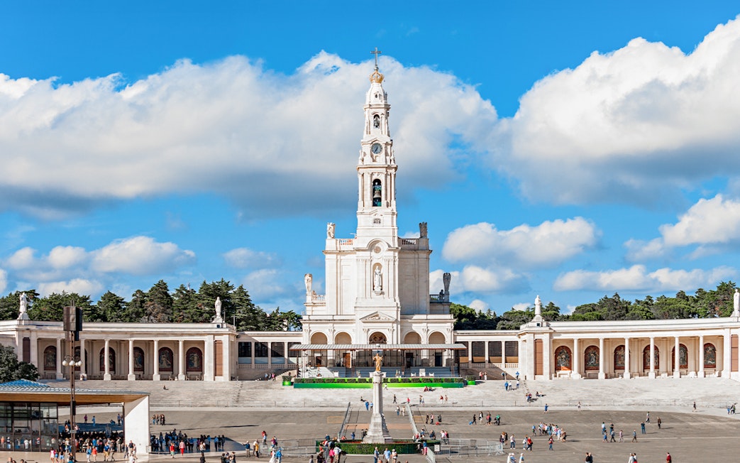 Sanctuary of Fatima with central basilica and visitors in the courtyard, Portugal.