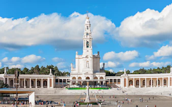 Sanctuary of Fatima with central basilica and visitors in the courtyard, Portugal.