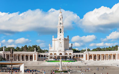 Sanctuary of Fatima with central basilica and visitors in the courtyard, Portugal.