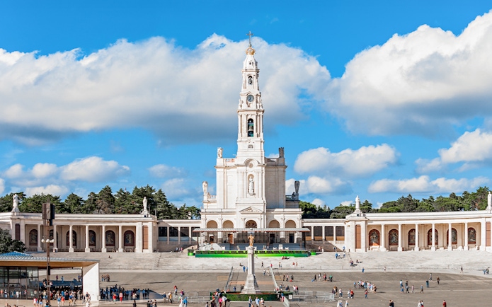 Sanctuary of Fatima with central basilica and visitors in the courtyard, Portugal.