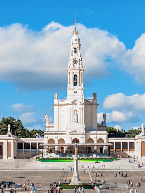 Sanctuary of Fatima with central basilica and visitors in the courtyard, Portugal.
