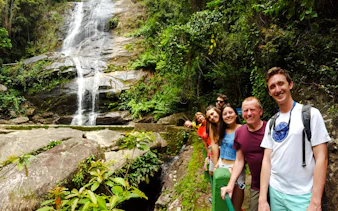 Group enjoying a waterfall in Tijuca Forest, Rio de Janeiro.