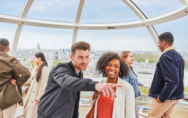Visitors on the London Eye overlooking the cityscape of London.