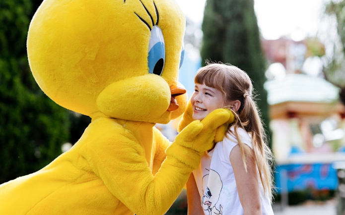 Tweety character greeting a smiling child at a meet and greet event.