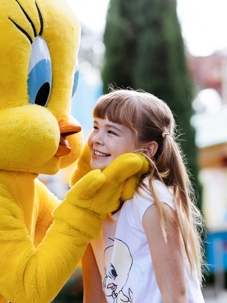 Tweety character greeting a smiling child at a meet and greet event.
