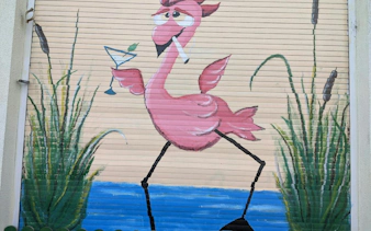 Flamingo mural with cocktail on a shutter in Bucharest, part of the Theatrical Odyssey tour.