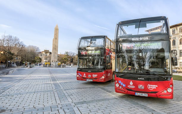 Double-decker buses at Sultanahmet Square, Istanbul with the Obelisk of Theodosius in the background.