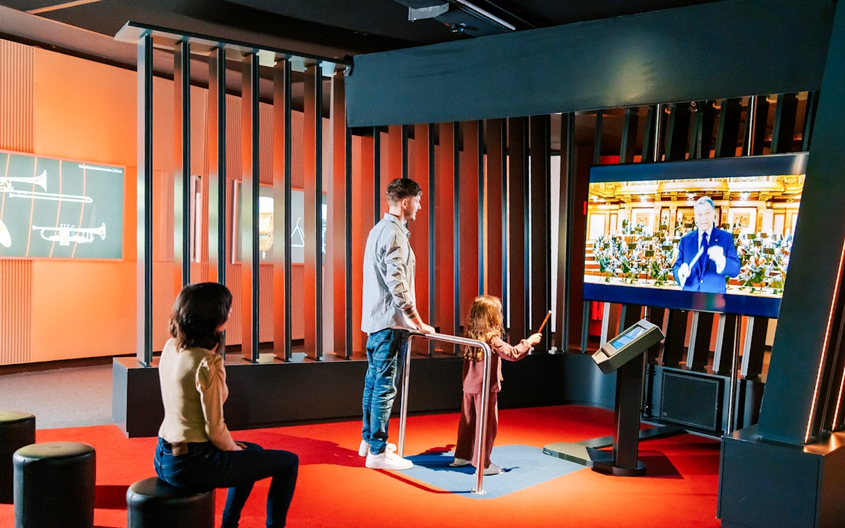 Guests interacting with a virtual conductor exhibit at Haus der Musik, Vienna.