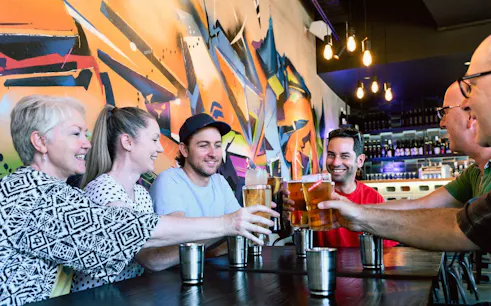Group enjoying drinks at a vibrant bar in Perth during a nightlife walking tour.