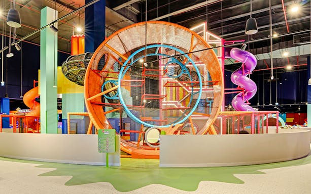 Indoor play area with colorful slides and climbing structures at Mission: Play! by Mattel.
