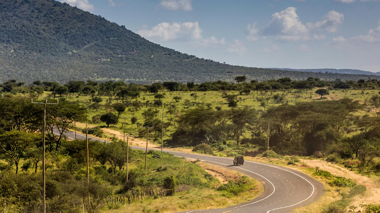 Curving road through savannah landscape between Narok and Masai Mara, Kenya.